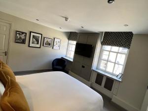 伍德斯托克旁池鲍尔宾馆的卧室配有白色的床和2扇窗户。
