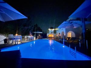 Al ḨaddādahVilla Calma - Vue Mer的夜间带遮阳伞的游泳池