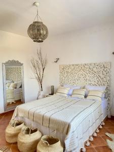 Al ḨaddādahVilla Calma - Vue Mer的卧室配有一张大床,地板上摆放着篮子