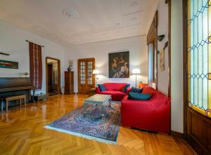 热那亚Castelletto Exclusive Terrace Penthouse的客厅配有红色的沙发和桌子