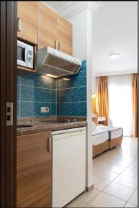 阿拉尼亚Kleopatra Tuna Apart Hotel的一个带水槽的厨房和一张位于客房内的床