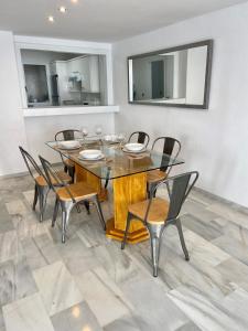 马贝拉Puerto Banus Duplex Centric WaterFront 3 Bedroom的一间带木桌和椅子的用餐室