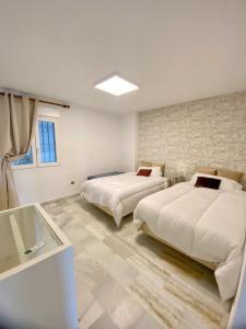 马贝拉Puerto Banus Duplex Centric WaterFront 3 Bedroom的白色客房的两张床,设有窗户