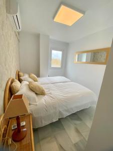 马贝拉Puerto Banus Duplex Centric WaterFront 3 Bedroom的卧室配有白色的床和窗户。