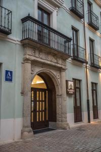 莱昂PALACIO REAL HOSTEL的通往大楼的入口,设有门和阳台