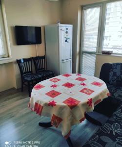 普列文Pleven Sunny Apartment的一间设有一张桌子的房间,配有红色和白色的被子