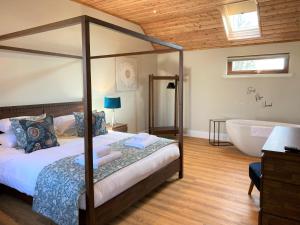 ForgandennyPheasant Lodge with Hot Tub的卧室配有1张床、浴缸和水槽。