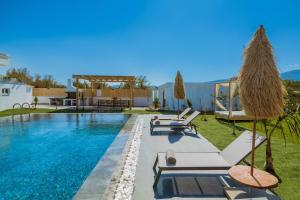 MouzákionSonel Luxury Villa, a Family Retreat, By ThinkVilla的一个带躺椅的游泳池以及别墅