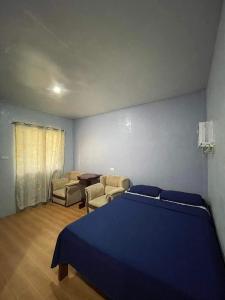 曼巴豪C - Side Inn的一间卧室配有蓝色的床和两把椅子