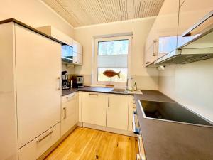 普鲁滕DarssAhoi的一间设有白色橱柜和窗户的大厨房