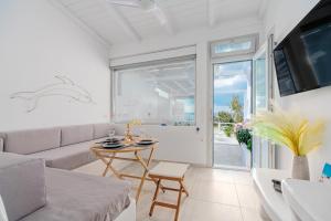 米克诺斯城Bella View Mykonos Town Suites的客厅配有沙发和桌子
