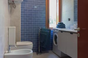 勒托阳尼Beach House Blue Holiday的蓝色瓷砖浴室设有卫生间和水槽