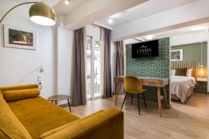 马贝拉Linda Boutique Hotel的客厅配有床和沙发