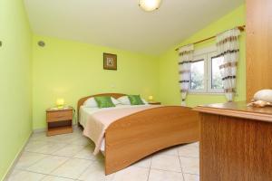 普利兹巴Apartments Villa Senija的一间卧室设有一张带绿色墙壁的床