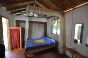 Castara卡斯塔拉度假屋的一间设有床铺的卧室,位于带窗户的房间内