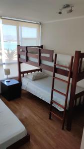 拉塞雷纳Hermoso apartamento de 2 dormitorios y 2 baños en Laguna del Mar La Serena的一间卧室设有两张双层床和梯子