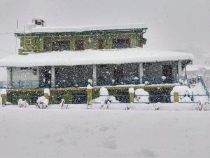 穆克缇斯瓦Chirping Orchard, Mukteshwar的一座被雪覆盖在院子里的建筑