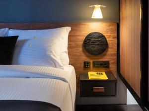 海若克利欧3 Pines Design Living的卧室配有白色的床和带台灯的床头柜。