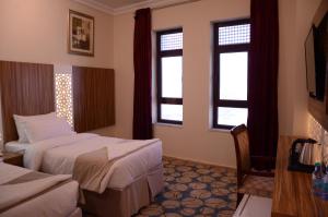 麦地那Artal International Hotel的酒店客房带两张床和两个窗户