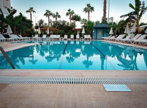 阿拉尼亚Bora Bora Butik Hotel的一个带椅子和棕榈树的大型游泳池