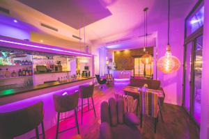 莱比锡莱比锡米特城市酒店的餐厅内拥有紫色照明的酒吧
