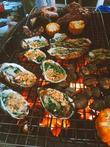 下龙湾The Bay - Ha Long Homestay的烤架上正在烹饪的一大堆食物