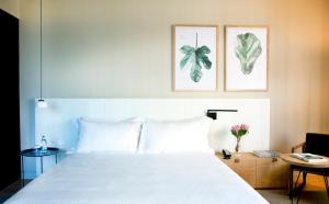 圣塞瓦斯蒂安Hotel Arima & Spa - Small Luxury Hotels的卧室配有一张白色床,墙上挂有两张照片