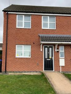 Kirkby in AshfieldKirkby House, 3 bedroom, sleeps up to 7 with sofa bed, holiday, corporate, contractor stays的红砖房子,有黑色的门