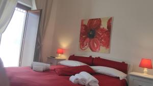 滨海波利尼亚诺茶乐村酒店的一间卧室设有红色的床和窗户。