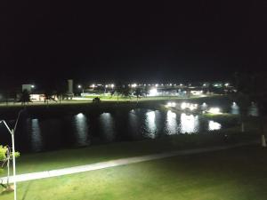 阿拉卡茹Apartamento em Resort Privativo的夜晚享有河流美景,配有灯光