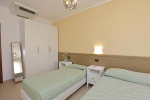 德瓦玛丽娜克里斯公寓式酒店的一间卧室配有两张床和镜子