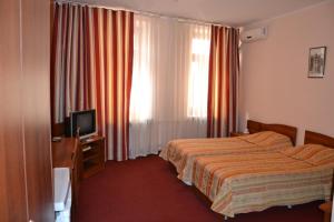 喀山布拉克酒店的酒店客房,配有床和电视