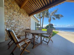 阿科达卡列塔Morning Star Villa的一个带石墙的庭院里的一张木桌子和椅子
