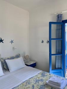 德里奥斯Cavos Studio by the sea (West)的一间卧室配有一张床和一个蓝色的门