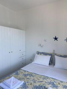 德里奥斯Cavos Studio by the sea (West)的卧室配有一张铺有白色床单的床,墙上挂着星星。