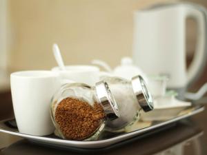 伯肯黑德利沃美景旅馆的装有杯子的盘子上的咖啡豆容器