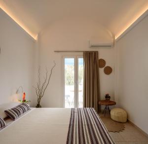 佩里萨Cal Day Rooms Santorini的卧室设有一张白色大床和一扇窗户。