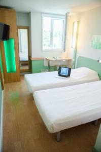 勒布朗-梅尼尔盖和纳巴黎勒布尔热机场宜必思快捷酒店的客房设有两张床,上面有笔记本电脑
