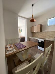 采蒂涅Apartmani Vila的厨房配有木桌和椅子