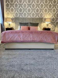 基拉尼奇拉伦屋酒店的一间卧室配有一张带2个床头柜的大床
