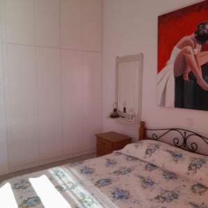 安德罗斯Esperides Sea的卧室配有一张床,墙上挂有绘画作品