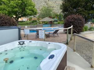 CawstonSimilkameen Wild Resort & Winery Retreat的庭院内的按摩浴缸,配有野餐桌