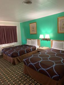 萨利纳萨利纳乡村宾馆的绿墙旅馆客房的两张床