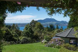 陶波Acacia Heights - Garden Cottage - Taupo的从房子的花园中可欣赏到湖景