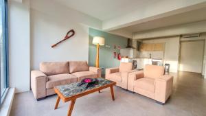 克罗托格Ramada Suites By Wyndham Seafront Coral Coast的客厅配有两把椅子和一张桌子