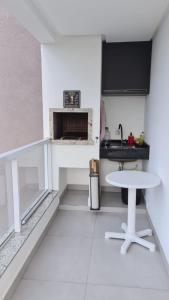 纳韦甘蒂斯Apartamento encantador na praia de Navegantes的白色的厨房配有桌子和壁炉