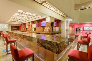 墨西哥城卡米诺皇家机场酒店的一间大酒吧,房间内设有红色椅子