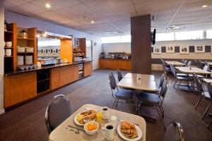 蒙特利尔拉贝尔套房酒店的一间带桌椅的用餐室和一间自助餐厅