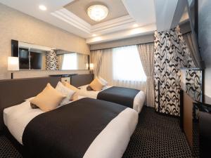 大阪APA Hotel Namba Shinsaibashi Higashi的酒店客房设有两张床和窗户。