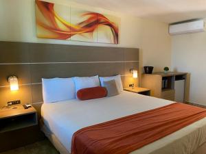 克布拉迪亚斯Hotel El Guajataca的酒店客房设有一张带红色枕头的大床